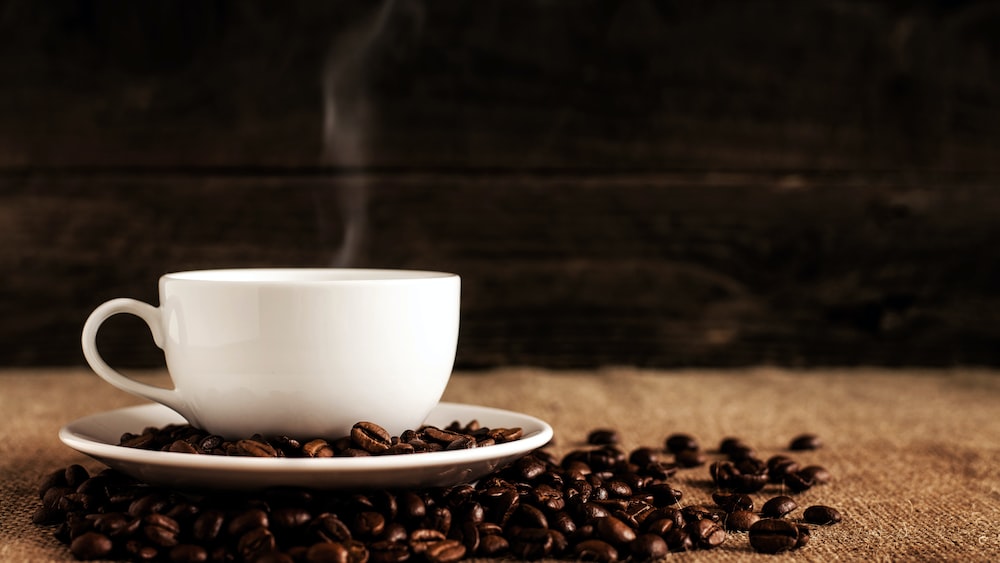 Caffeine Boost: Coffee in a White Ceramic Mug with Coffee Beans