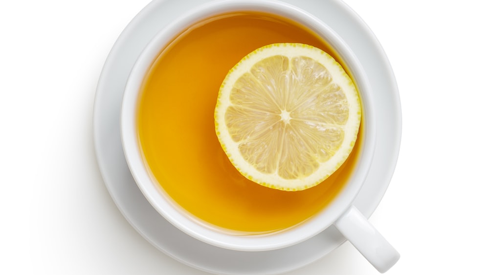Comparison of Rooibos Tea and Black Tea: Isolated Green Tea in a White Ceramic Mug with Lemon Juice