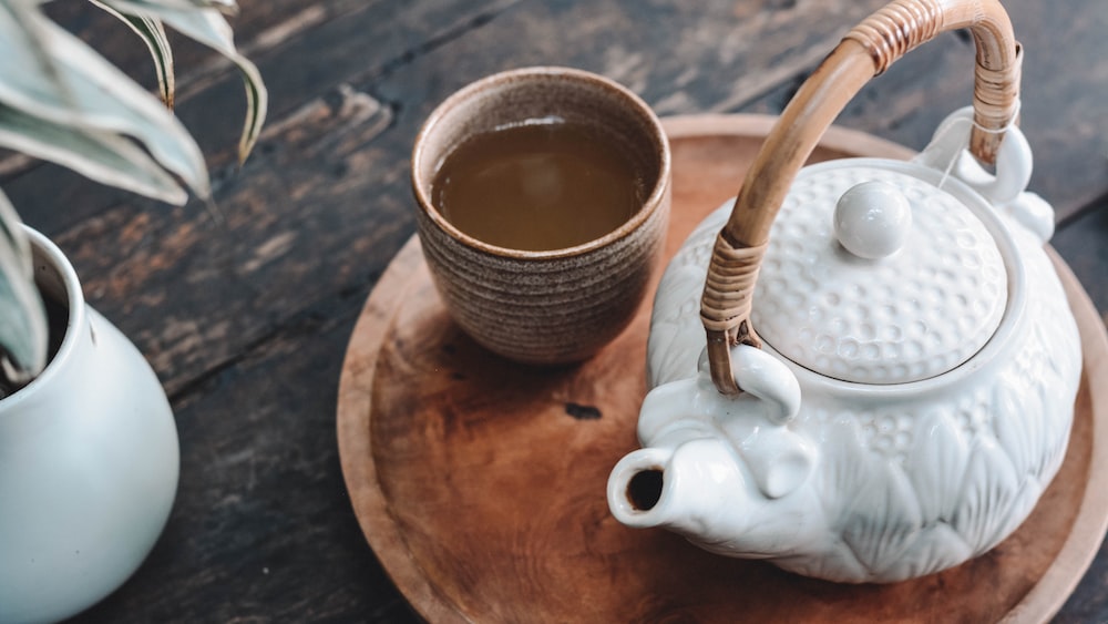 Comparison of Tea and Soda: Aesthetic Teapot on Wooden Tray