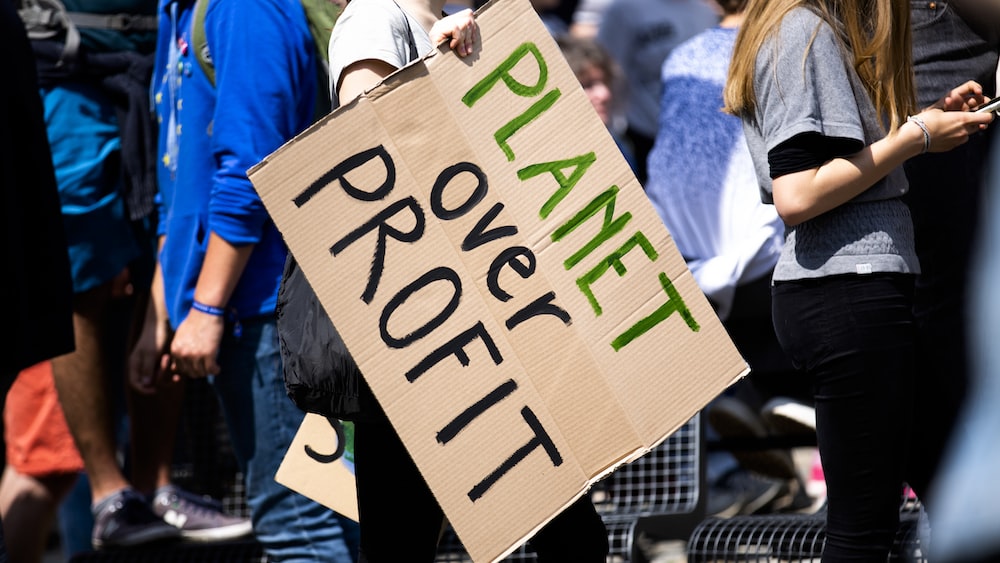Global Climate Strike: Woman Holds Planet over Profit Placard