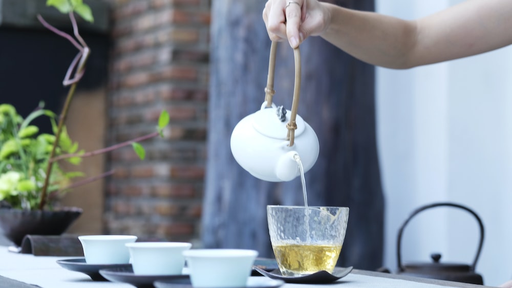 Longjing Tea Brewing Guide: Tea Ceremony with a Person Holding a Kettle