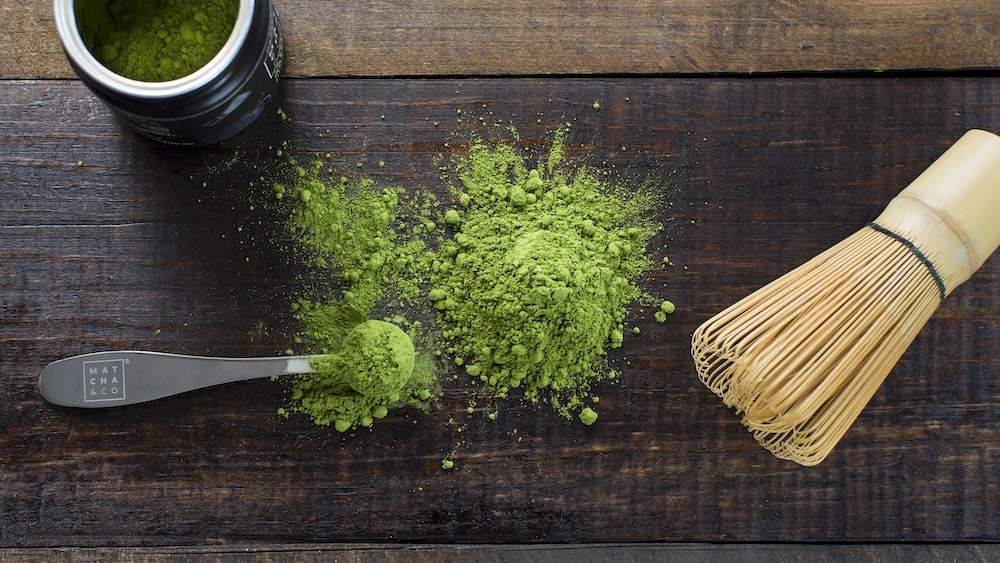 Matcha Tea and Accessories: A Green Powder and Spoon on a Board