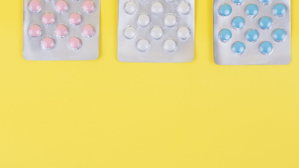 Medication Interaction: Pink, White, and Yellow Pills on a Yellow Background