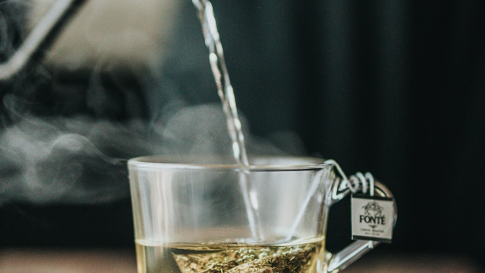 Pu Erh Tea Pouring into Clear Glass Teacup