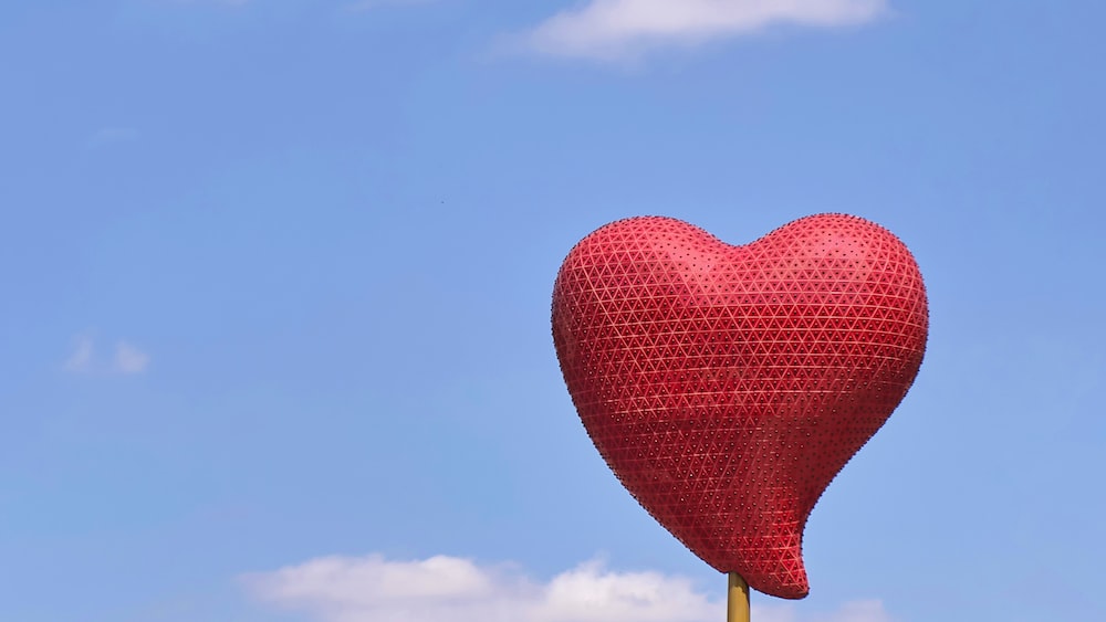 Rebellious Love: A Heart Balloon Soaring Under a Blue Sky