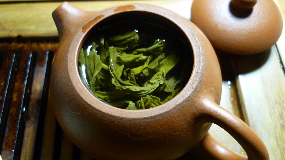 Refreshing Green Tea: Leaves and Liquid in a Teapot