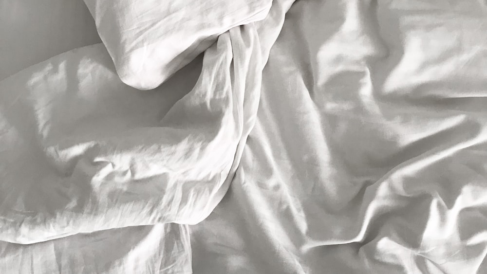 Restful Sleep: Unmade Bed with White Sheets and Pillows