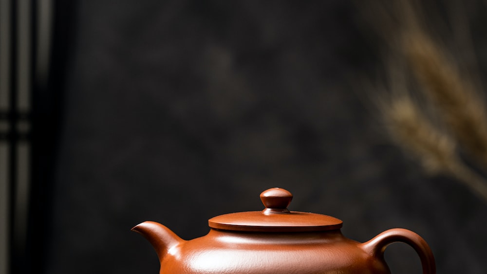 Steeping Goodness: A Brown Ceramic Teapot on a Wooden Table
