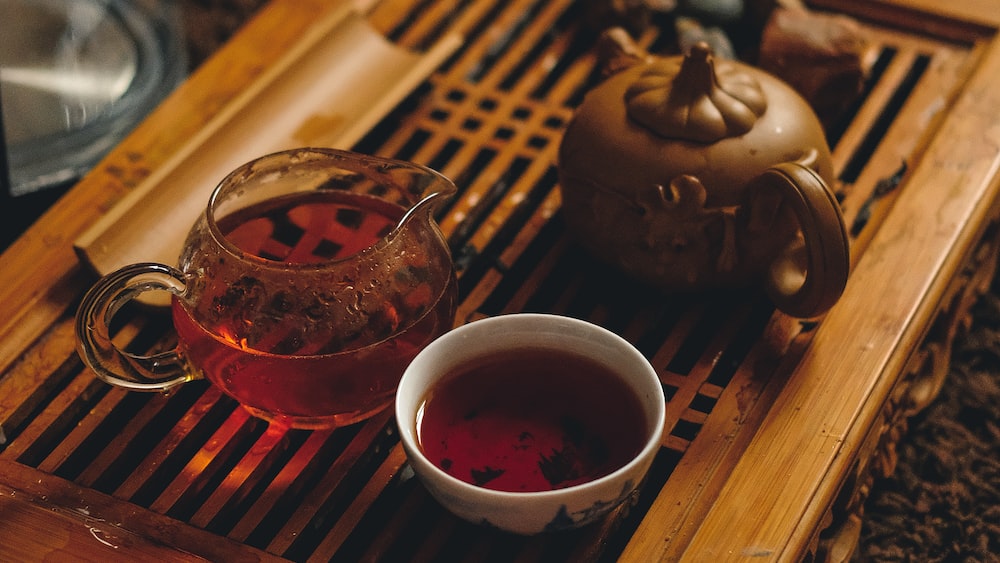 Tea: A Selective Focus Photography of a Cup and Bowl with a Brown Teapot