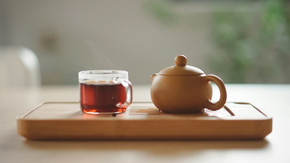 Tea: Clear Glass Cup of Tea Next to a Ceramic Teapot