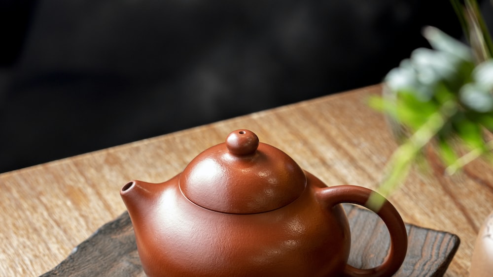 Tea Time: A Brown Ceramic Teapot on a Wooden Table