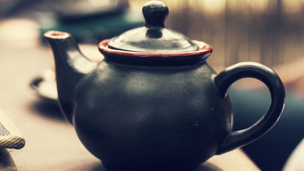 Tea brewing essentials: Black and red ceramic kettle.