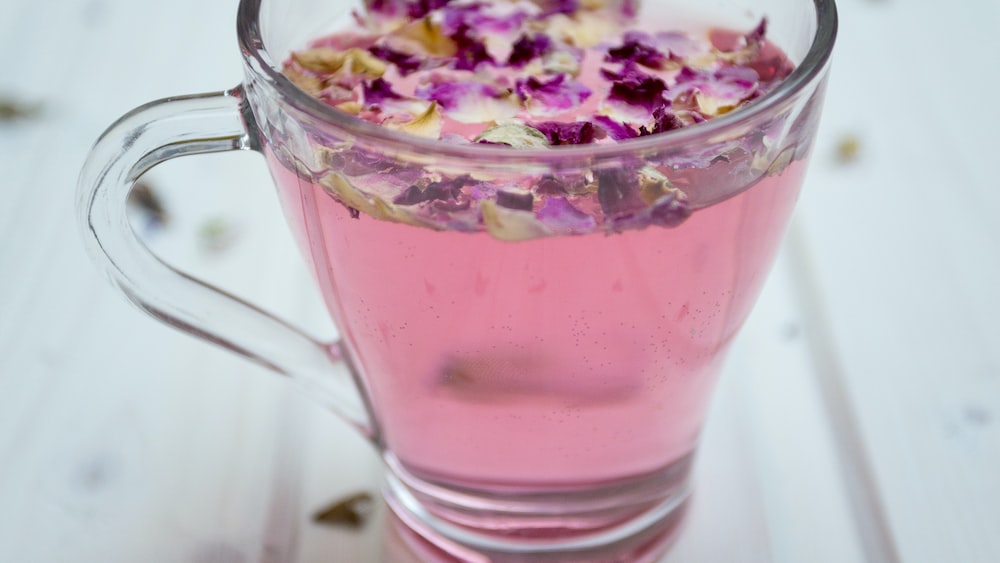 Tea in Clear Glass Cup Surrounded by Petals
