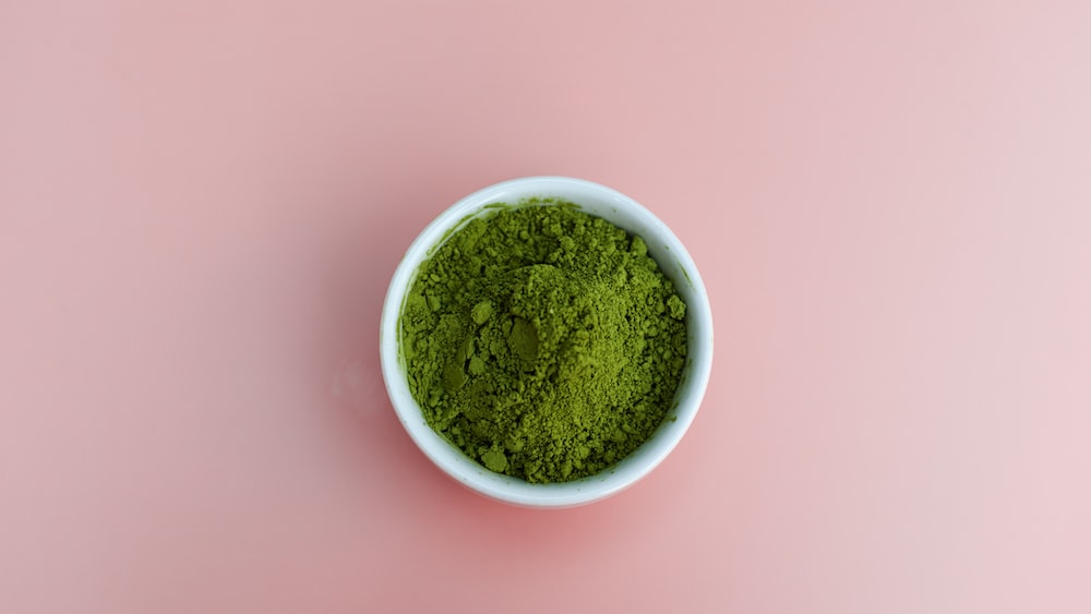 Vibrant Matcha Powder on Pastel Pink Background